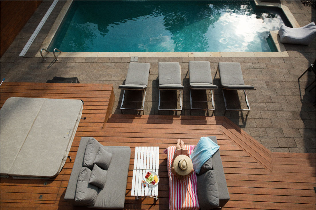 Deck de madera junto a una piscina protegido con Impra Decks Aqua